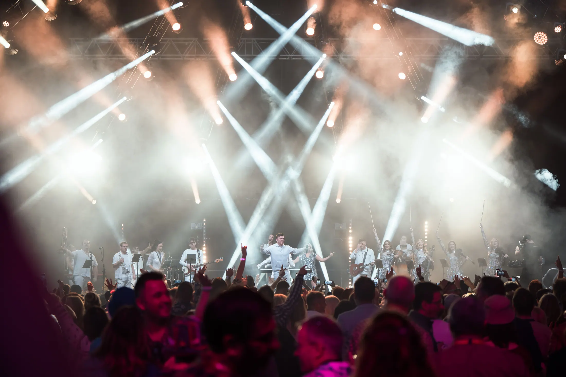 An In Symphony production on a festival main stage, lighting rig blazing over a packed crowd